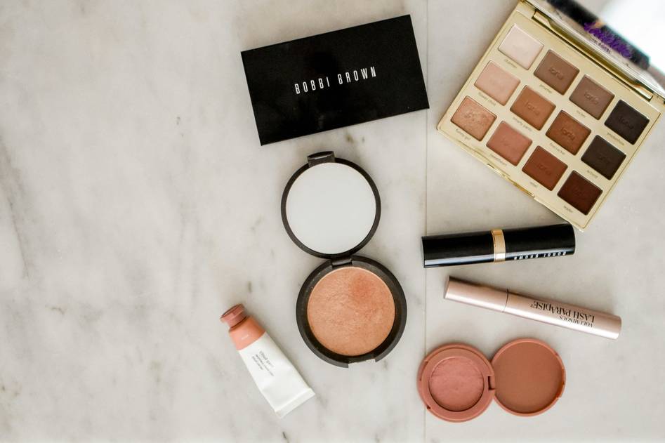 Makeup brushes and palette on marble vanity with soft lighting