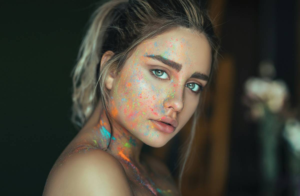 Close-up of whimsical face paint showing ghost-blended highlights on model's cheekbones