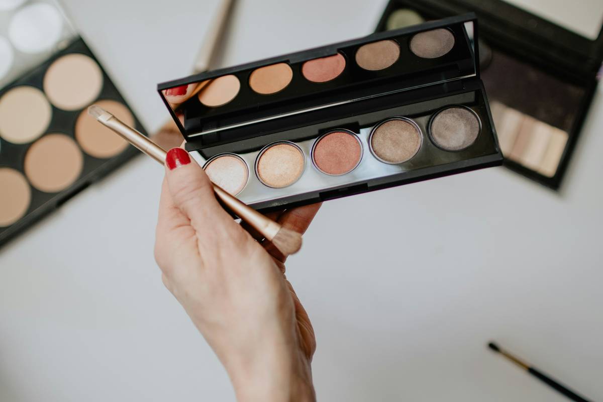 Close-up of makeup artist blending concealer under model's eyes with fingertip for seamless concealer blend