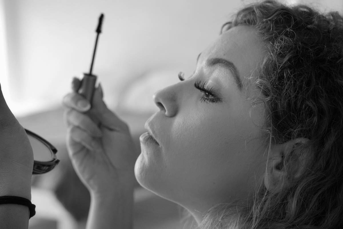 Close-up of woman using eyelash curler with mascara curl method demonstrated on natural lashes