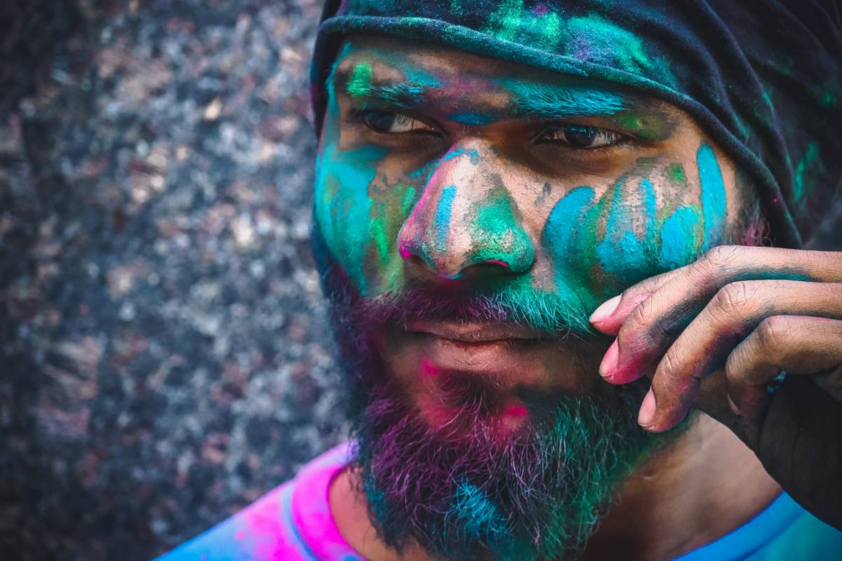 Artist applying whimsical face paint with fine brushes and vibrant colors