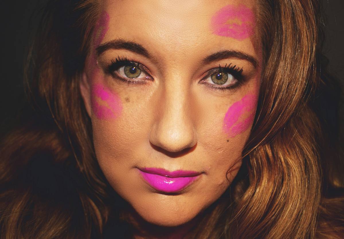Model with natural makeup showcasing playful cheek tint on dewy skin